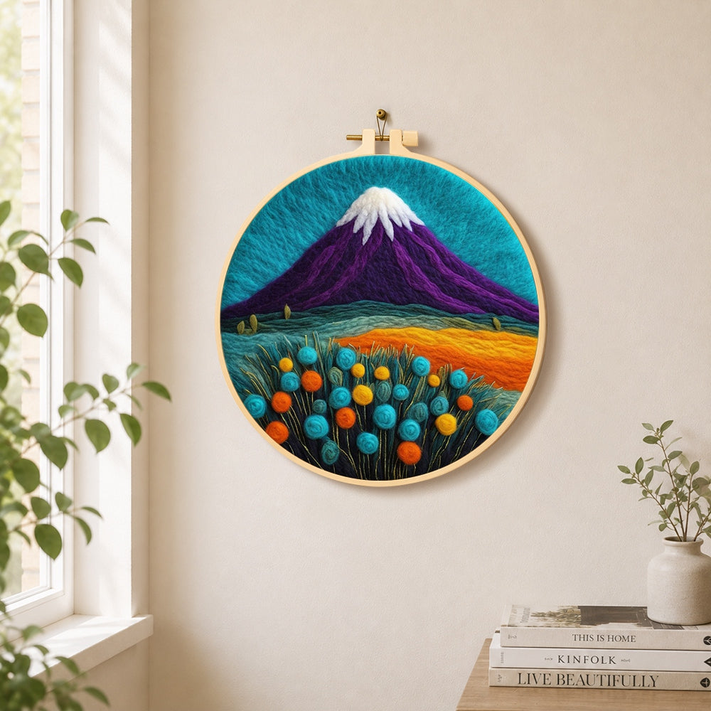 Purple volcano and flowers needle felt wall art displayed in a bright home interior