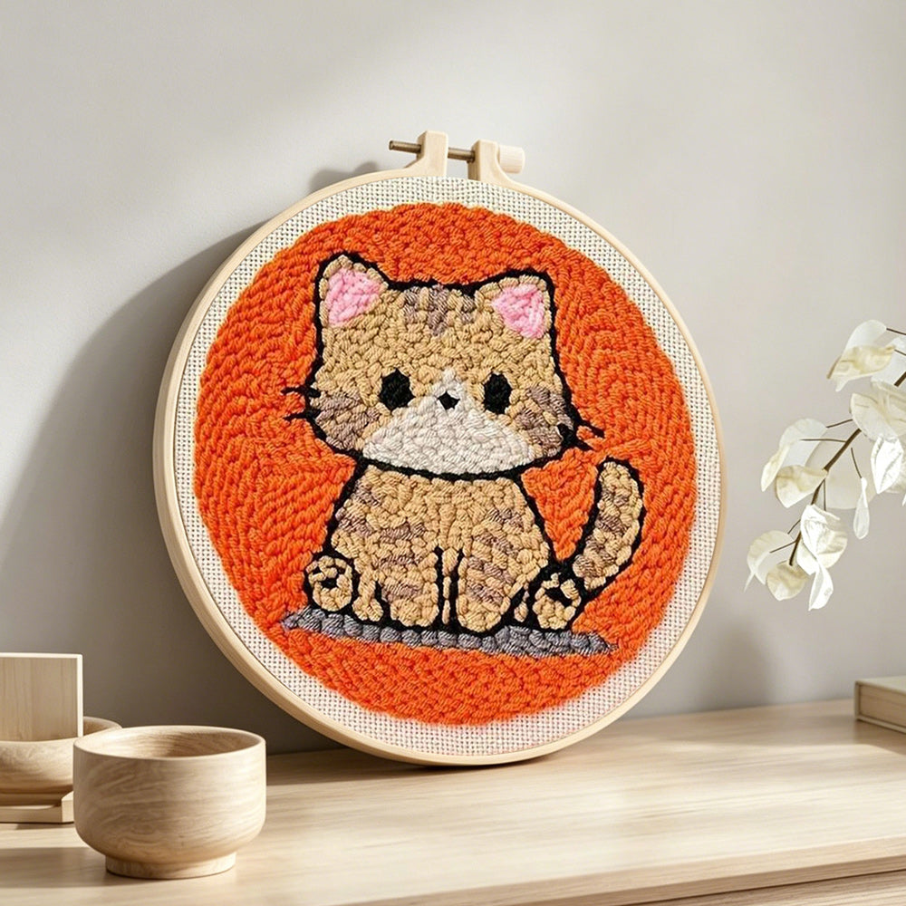 Quiet little orange cat punch needle artwork displayed on a table