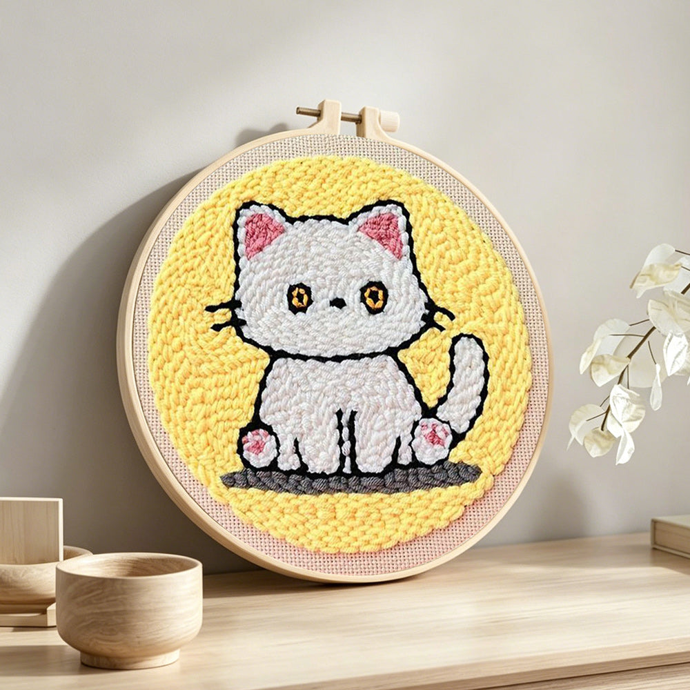 Quiet little white cat punch needle artwork displayed on a table