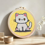 Quiet little white cat punch needle artwork displayed on a table