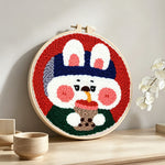 Rabbit drinking bubble tea punch needle artwork displayed on a table