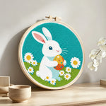 Rabbit with easter egg punch needle artwork displayed on a table