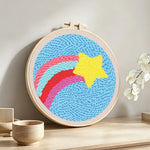 Rainbow arcs and star punch needle artwork displayed on a table