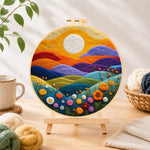 Finished rainbow hills with blooming flowers at sunset needle felting displayed on a wooden easel