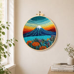 Rainbow layered sky and snow-capped mountain needle felt wall art displayed in a bright home interior