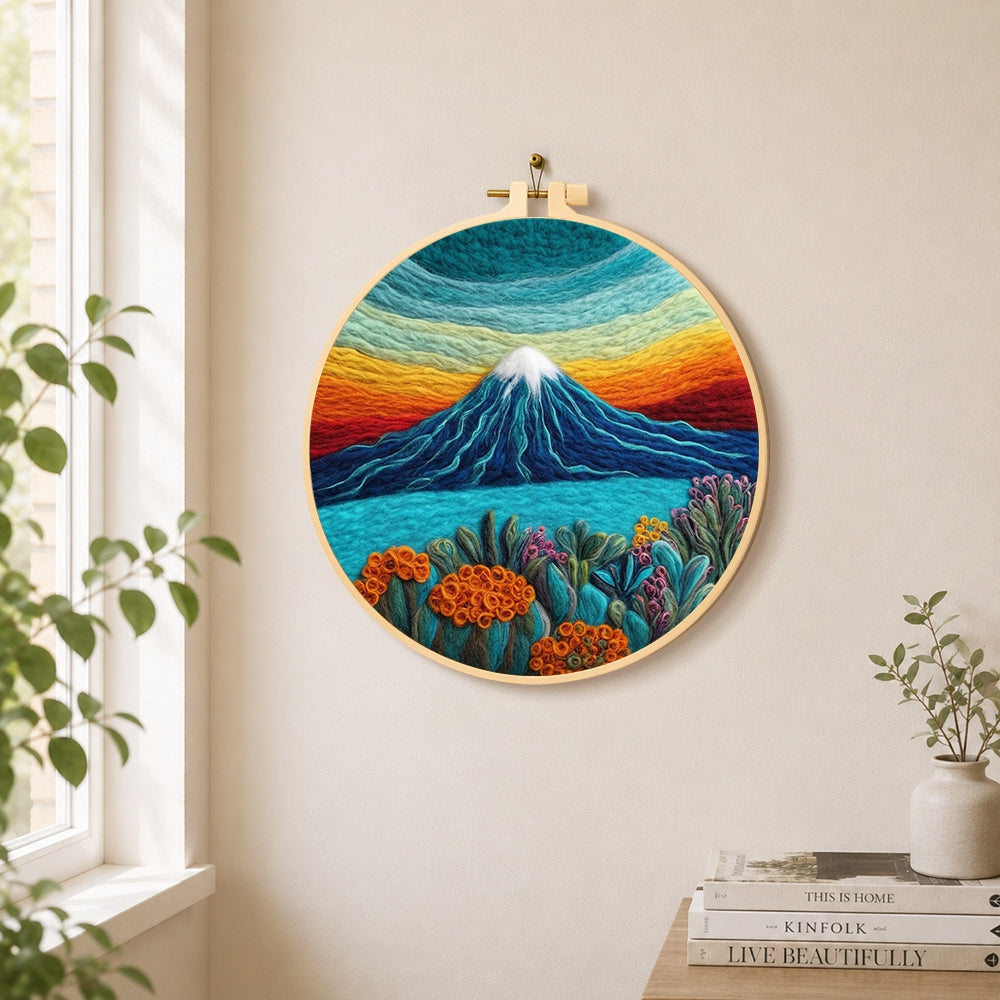 Rainbow layered sky and snow-capped mountain needle felt wall art displayed in a bright home interior