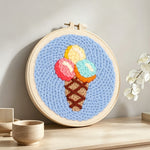 Rainbow scoop ice cream cone punch needle artwork displayed on a table
