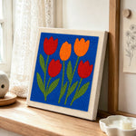 Red and orange tulip flowers punch needle artwork displayed on a table