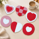 Red and pink checkered heart punch needle coasters used for home decoration