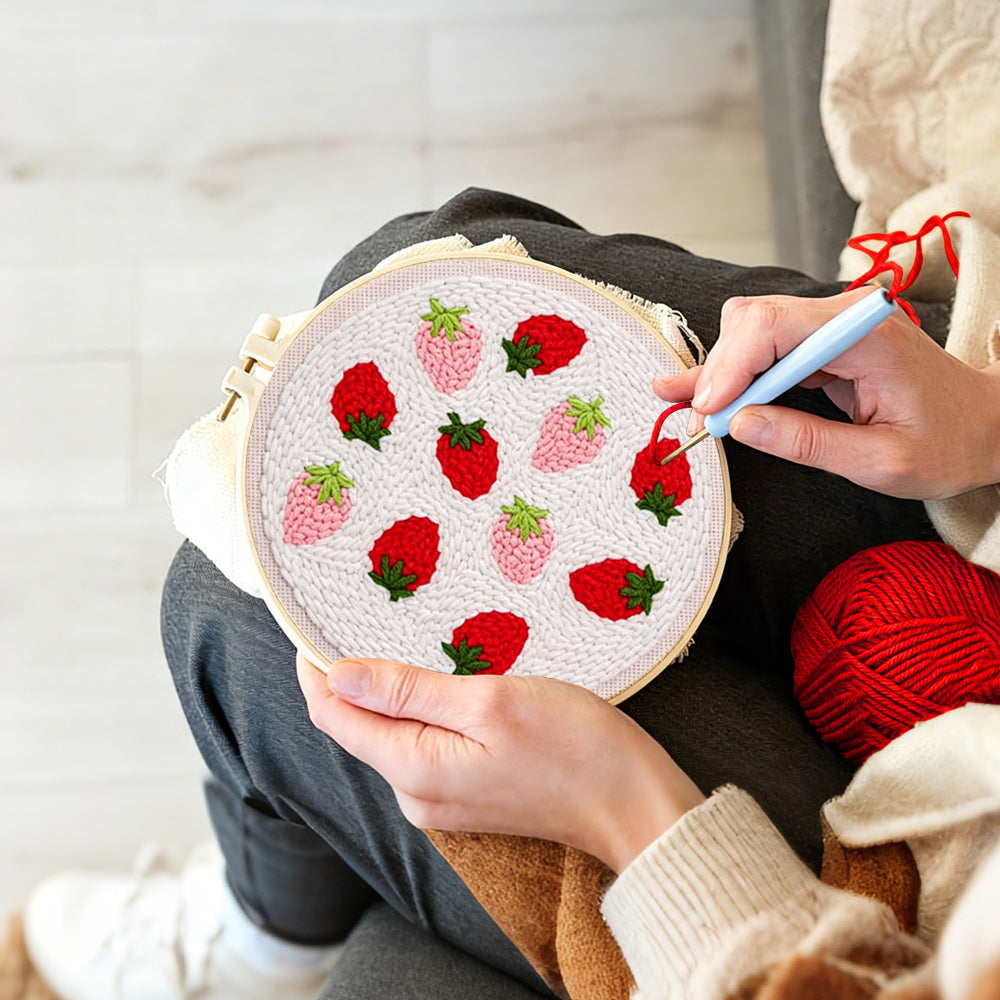 Creating handmade red and pink strawberries punch needle artwork