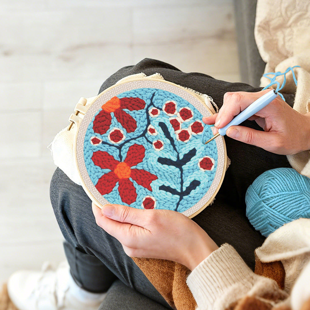Creating handmade red berries and flowers punch needle artwork