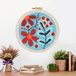 Finished red berries and flowers artwork displayed on a wall