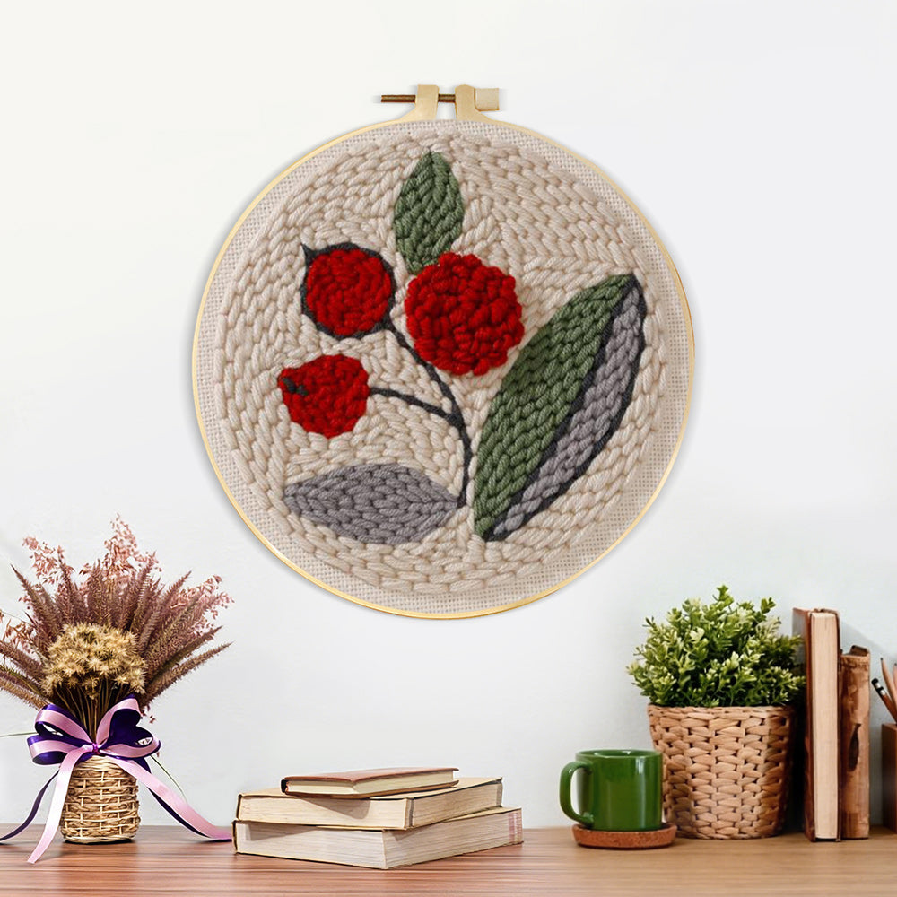 Finished red berries with green leaves artwork displayed on a wall