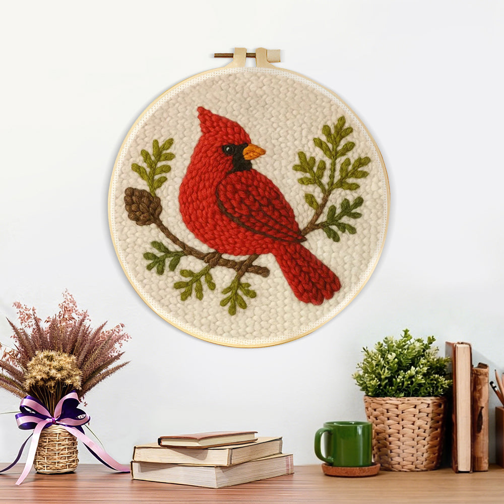Finished red cardinal and pine cone branch artwork displayed on a wall