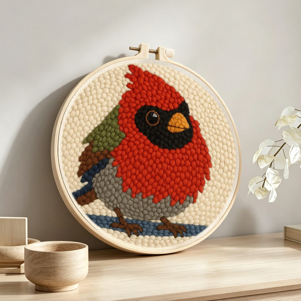 Red cardinal bird punch needle artwork displayed on a table