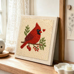 Red cardinal with heart punch needle artwork displayed on a table
