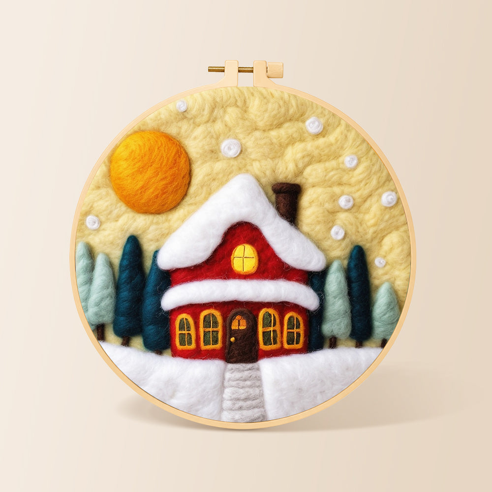 Red cottage under snowy yellow sky needle felting kit for beginners with a round wooden frame