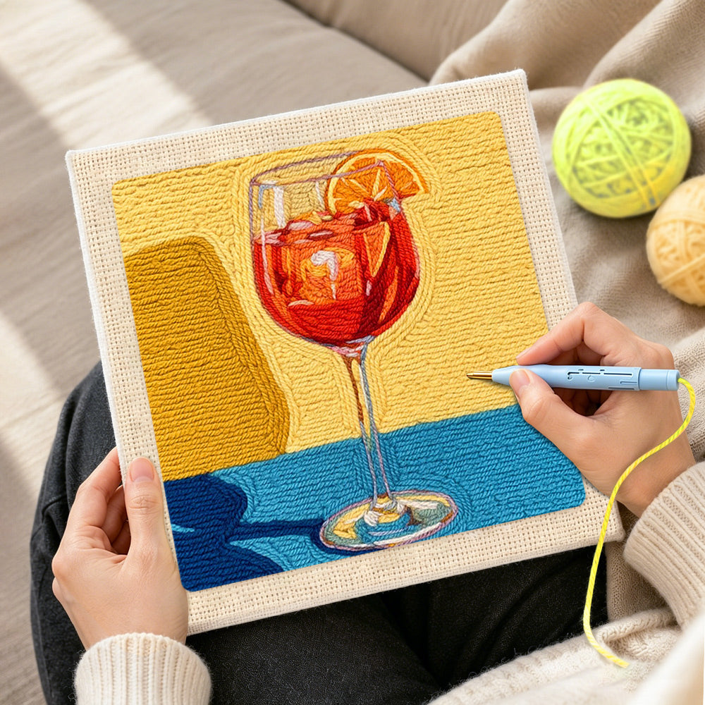 Creating handmade red drink with orange slice punch needle artwork
