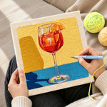 Creating handmade red drink with orange slice punch needle artwork