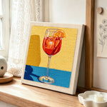 Red drink with orange slice punch needle artwork displayed on a table