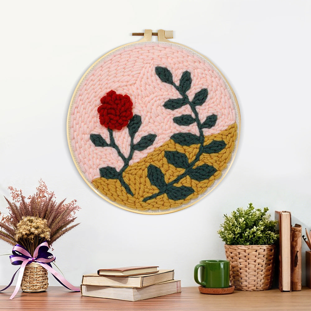 Finished red flower and green leaves artwork displayed on a wall
