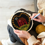 Creating handmade red house with “home” heart wreath punch needle artwork