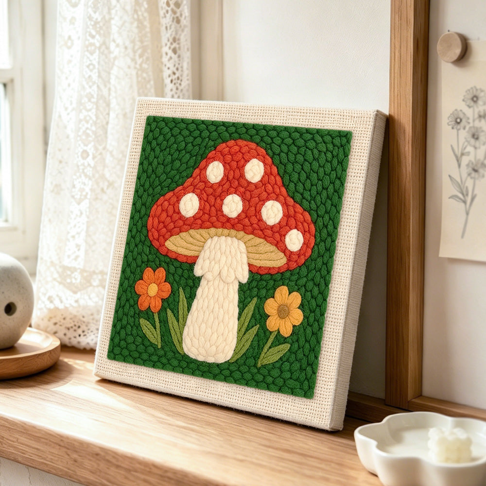 Red mushroom with white spots punch needle artwork displayed on a table