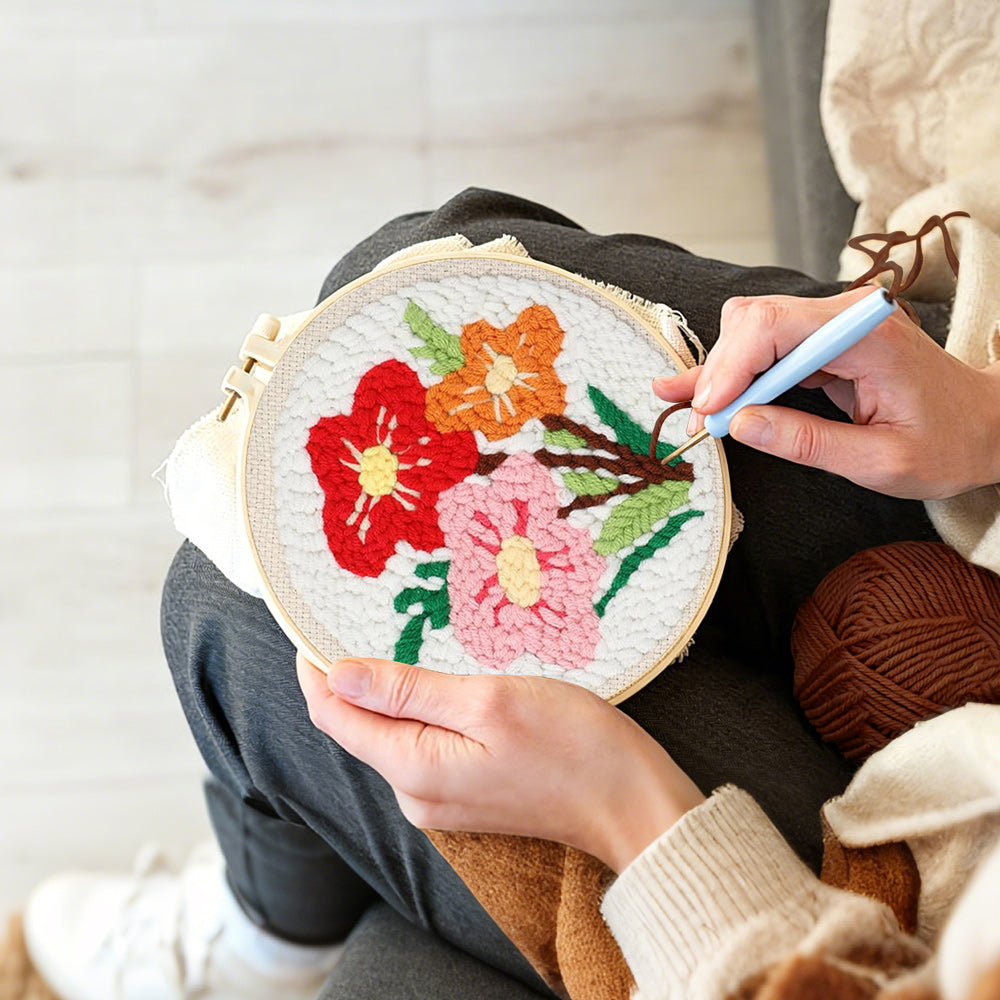 Creating handmade red, pink and orange floral bouquet punch needle artwork