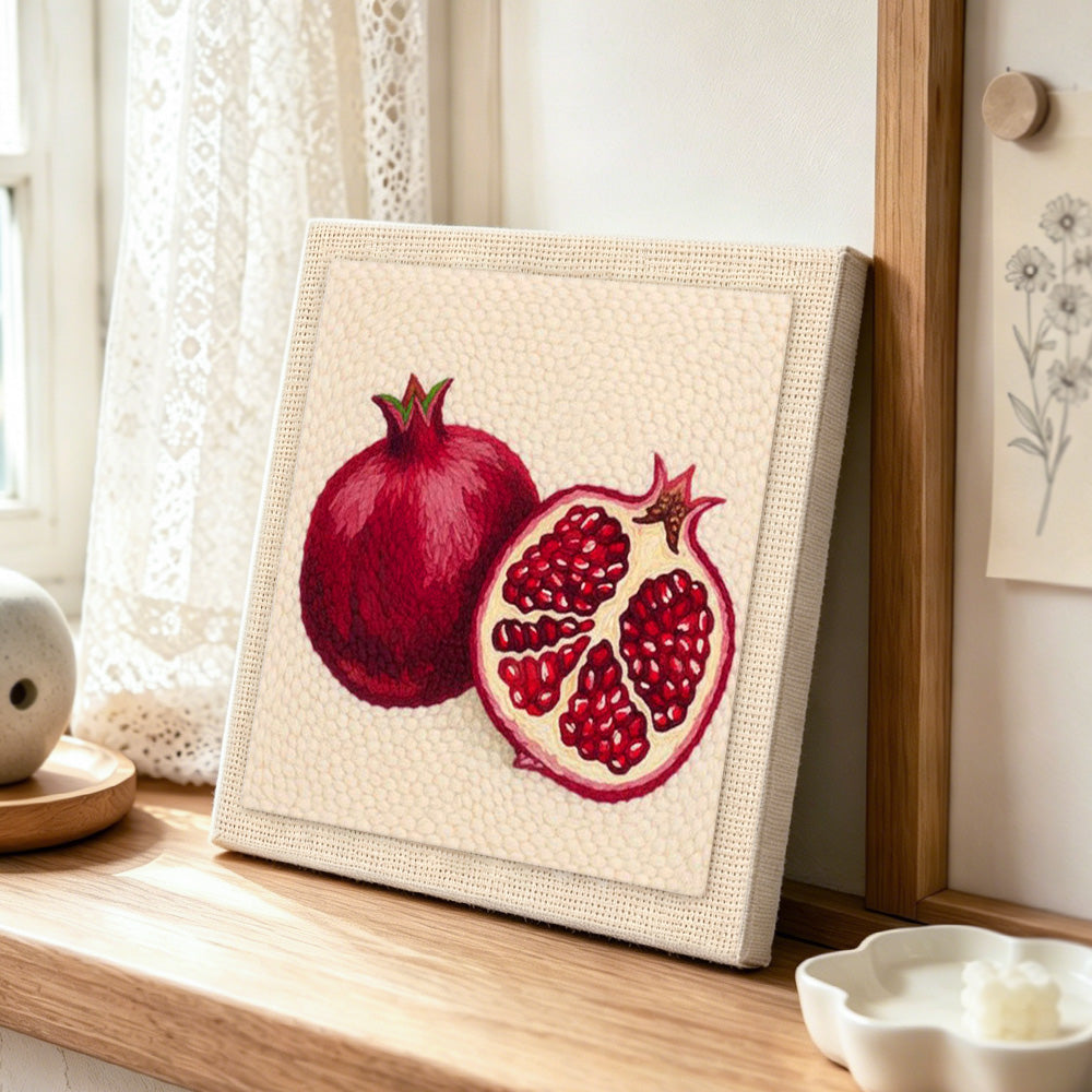 Red pomegranate punch needle artwork displayed on a table