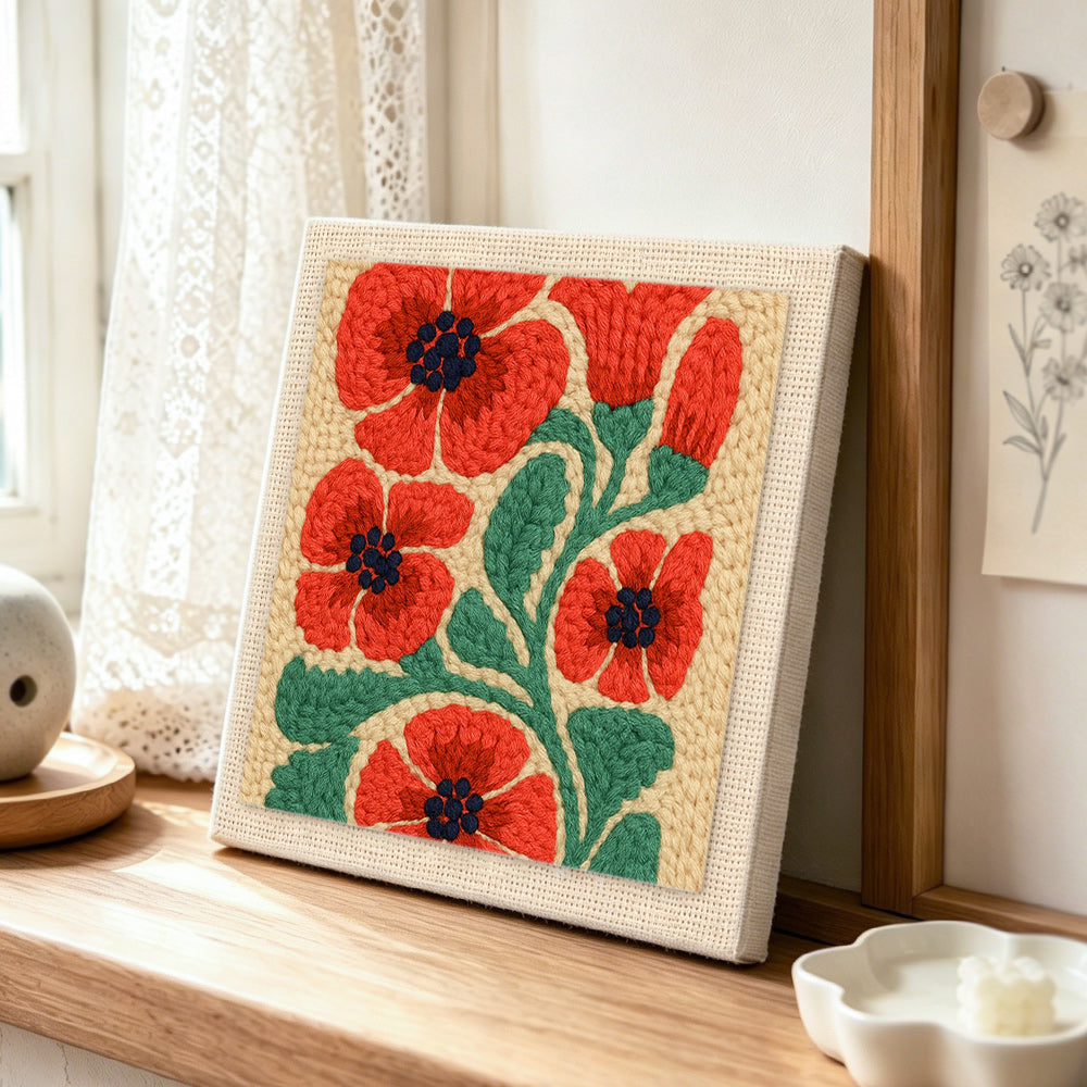 Red poppies punch needle artwork displayed on a table