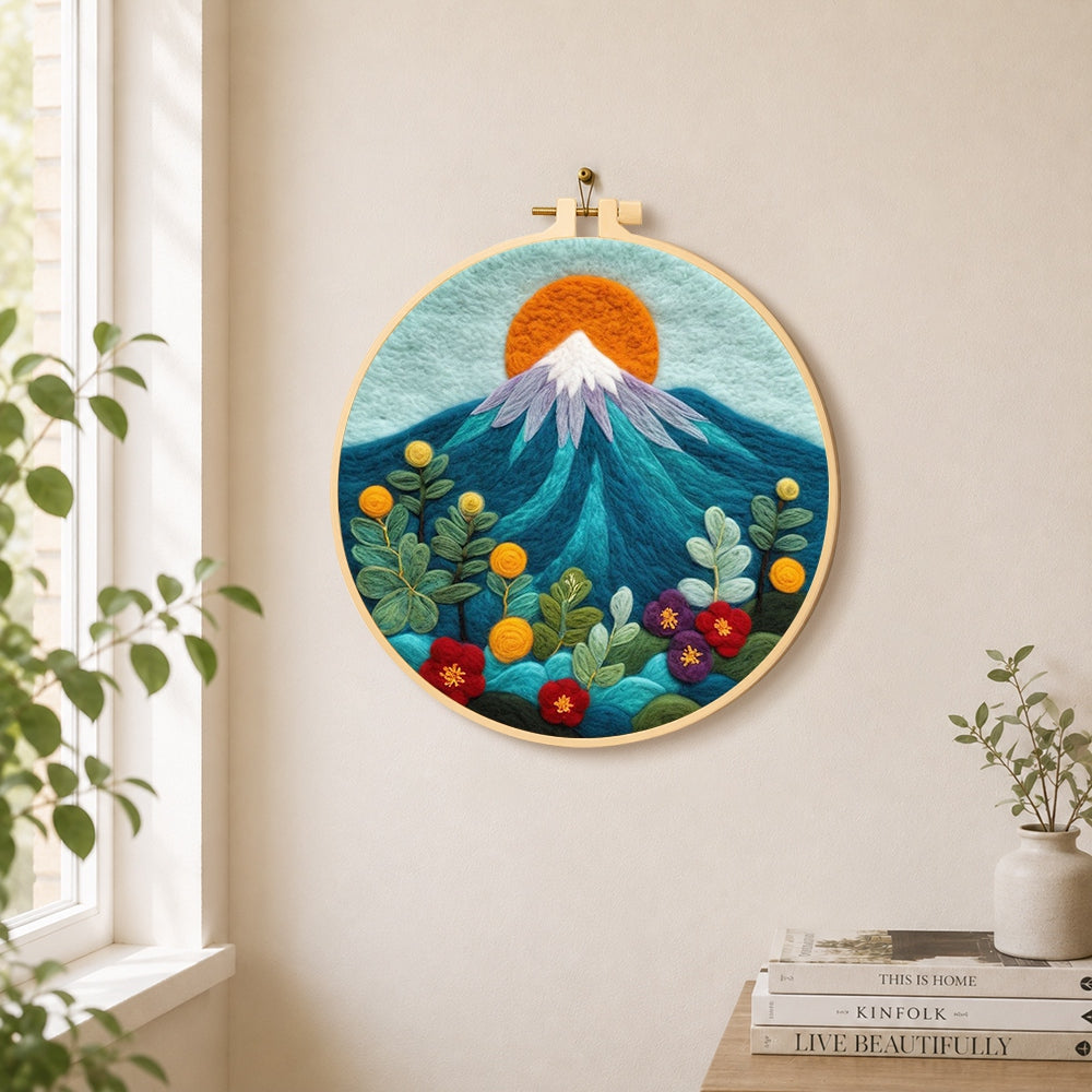Red sun over snowy peaks needle felt wall art displayed in a bright home interior
