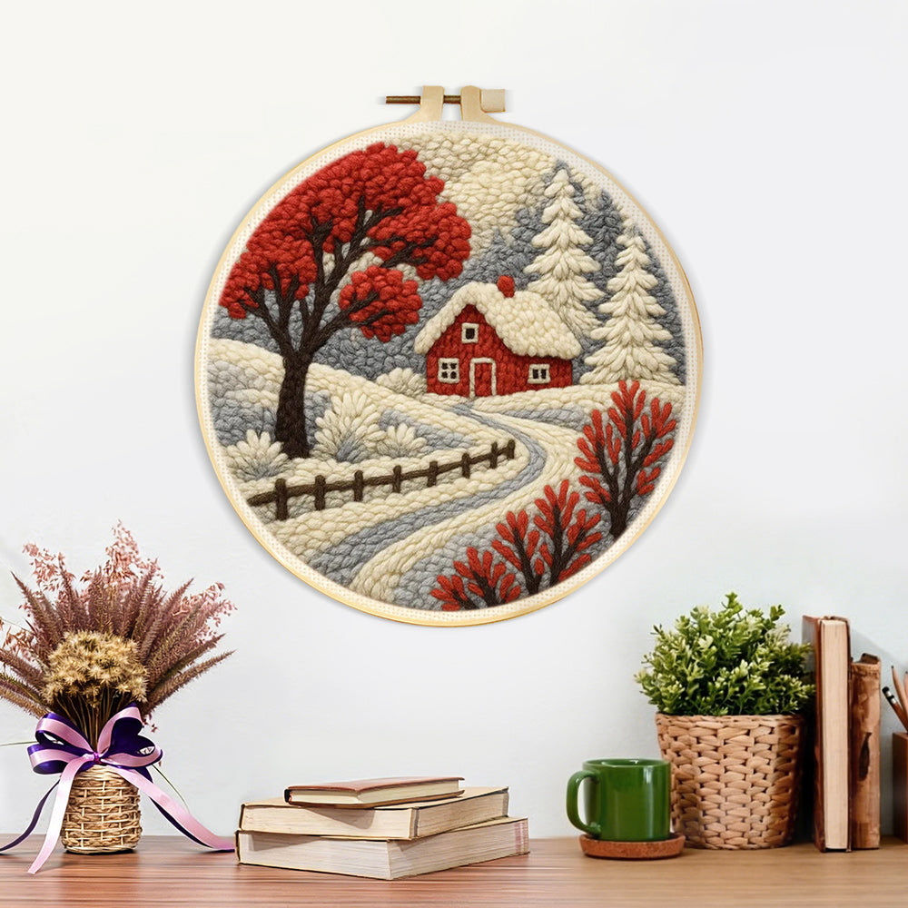Finished red winter tree and snowy cottage artwork displayed on a wall