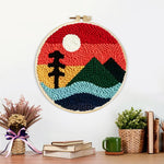 Finished ree and green mountain under red sky artwork displayed on a wall