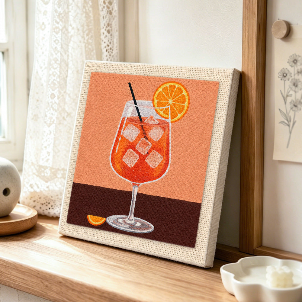 Refreshing orange cocktail with ice cubes punch needle artwork displayed on a table