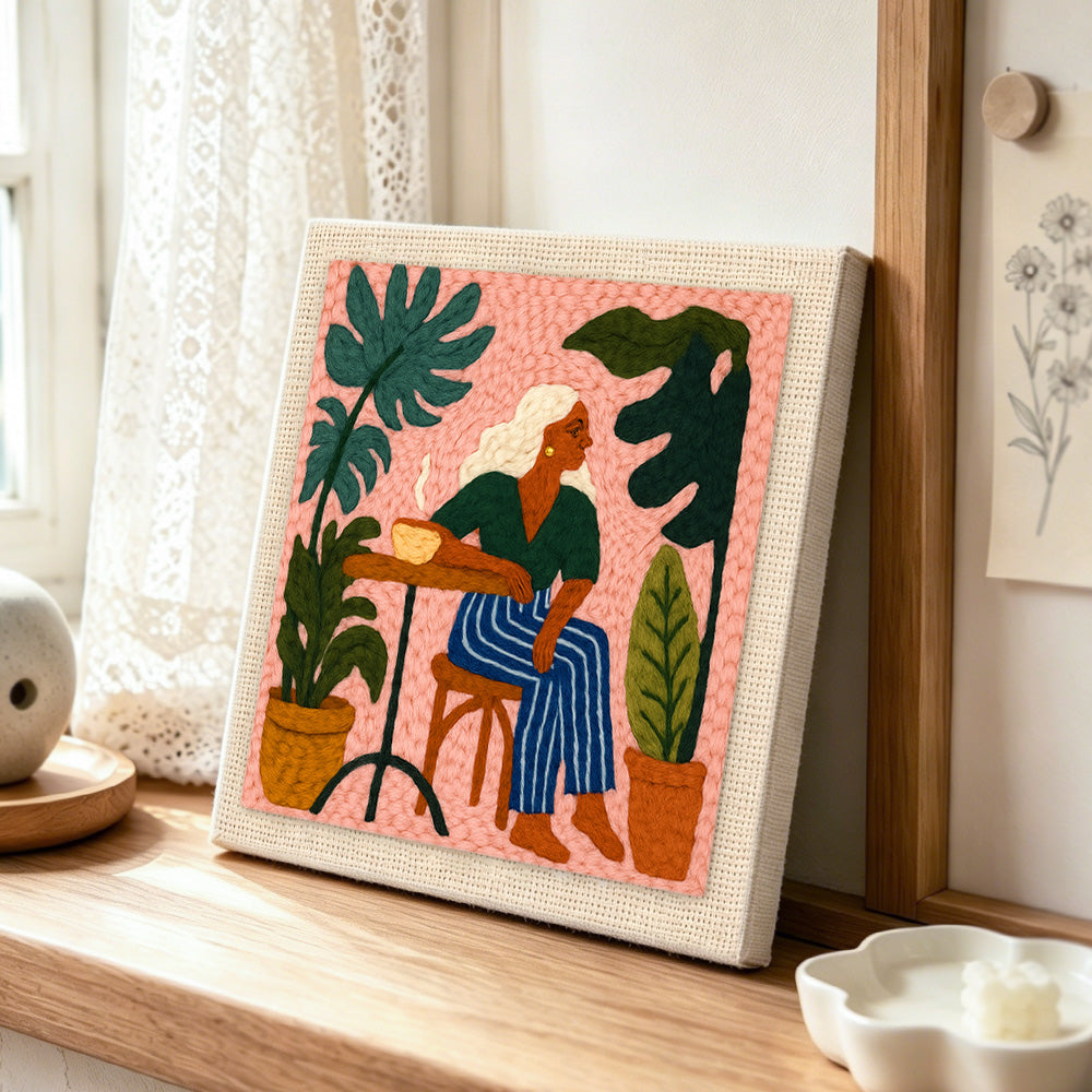 Relaxing woman and houseplants punch needle artwork displayed on a table