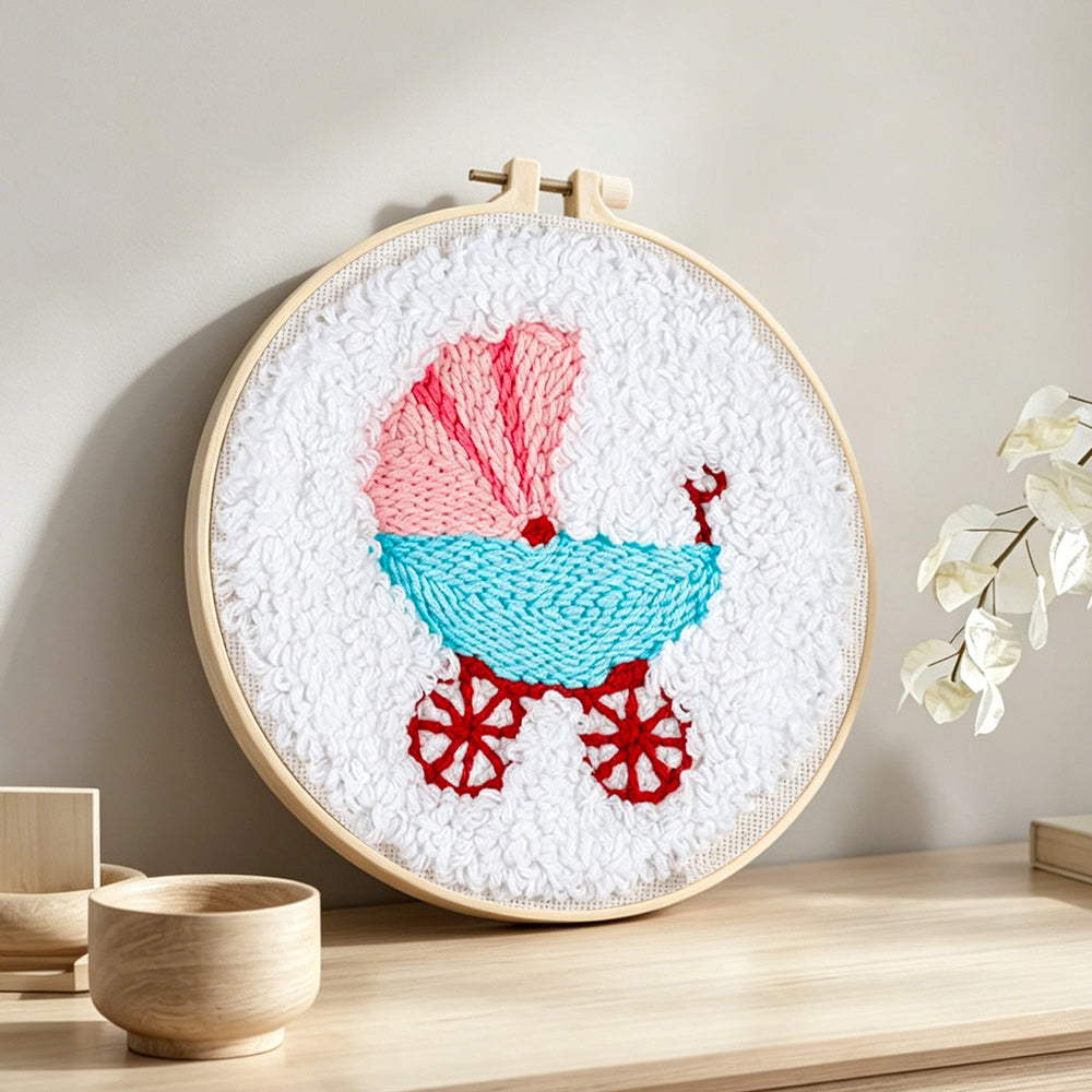 Retro baby pram punch needle artwork displayed on a table