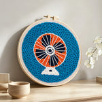 Retro electric fan punch needle artwork displayed on a table
