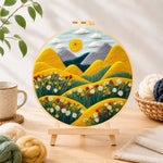 Finished rolling golden hills and daisies needle felting displayed on a wooden easel