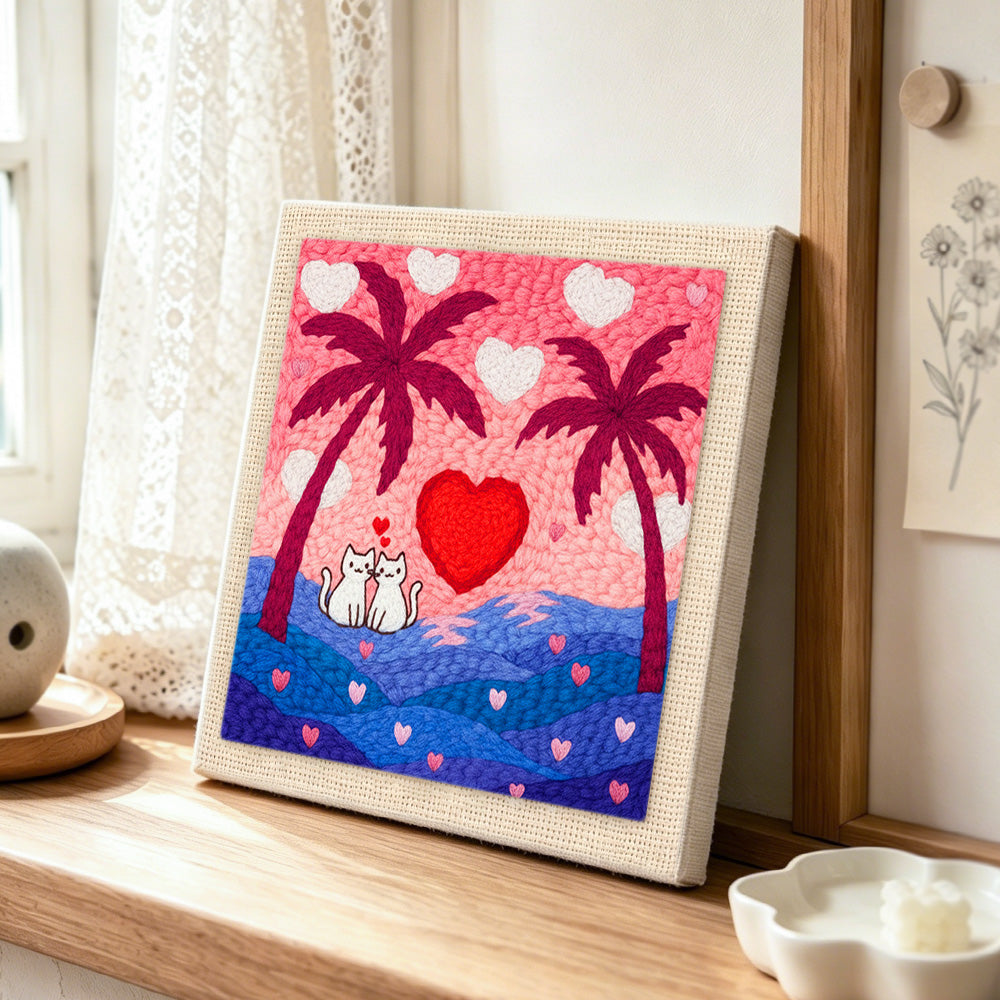 Romantic cat couple, heart sunset and palm trees punch needle artwork displayed on a table