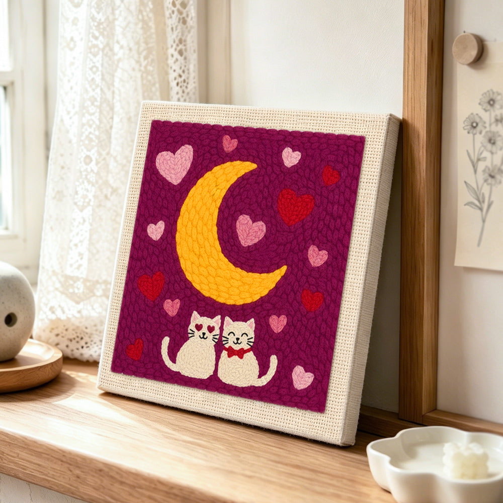 Romantic cat couple under moonlit night punch needle artwork displayed on a table