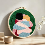 Romantic embrace punch needle artwork displayed on a table