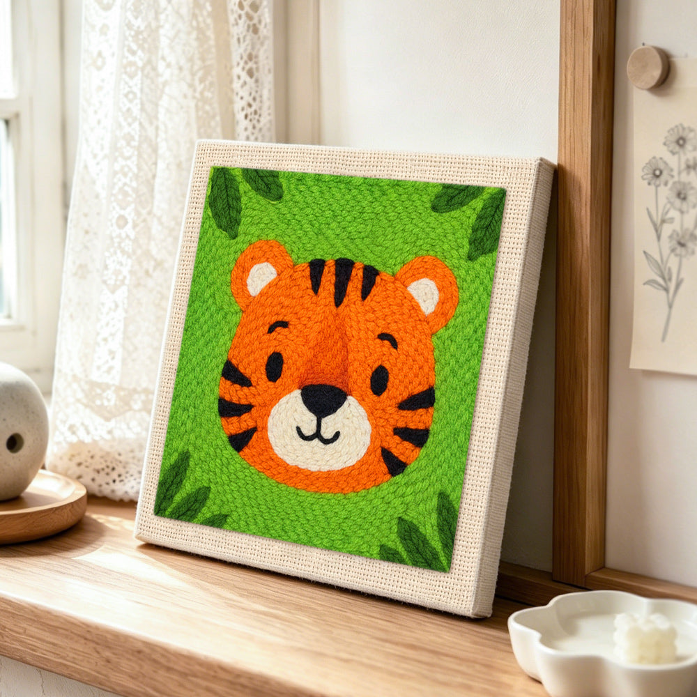 Round and cuddly tiger face punch needle artwork displayed on a table
