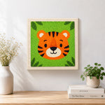 Finished round and cuddly tiger face artwork displayed on a wall