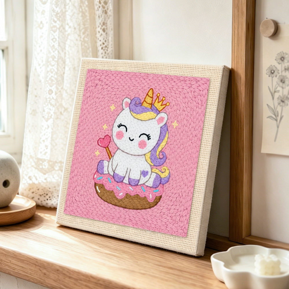 Royal unicorn on donut punch needle artwork displayed on a table