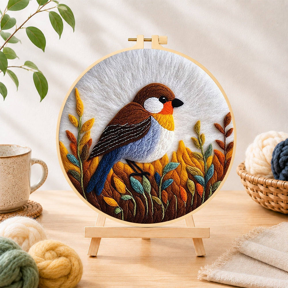 Finished rustic autumnal bird on golden grasses needle felting displayed on a wooden easel