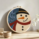 Rustic snowman portrait punch needle artwork displayed on a table