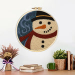 Finished rustic snowman portrait artwork displayed on a wall