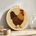 Rustic vintage rooster punch needle artwork displayed on a table