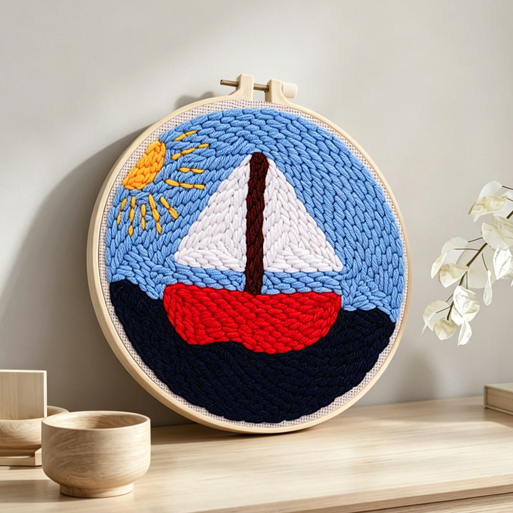 Sailboat on the sea under the sunlight punch needle artwork displayed on a table