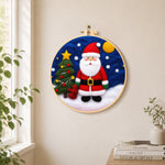 Santa and christmas tree needle felt wall art displayed in a bright home interior